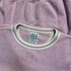 Close-up of a purple sweatshirt with a visible brand label.